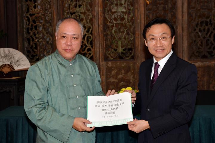 澳門特別行政區社會文化司司長譚俊榮(圖右)向澳門之國家級“非遺"-澳門道教科儀音樂傳承人吳炳鋕(圖左)頒發傳習經費