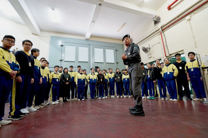 青年聚精會神聽取獄警人員介紹監獄的保安設施