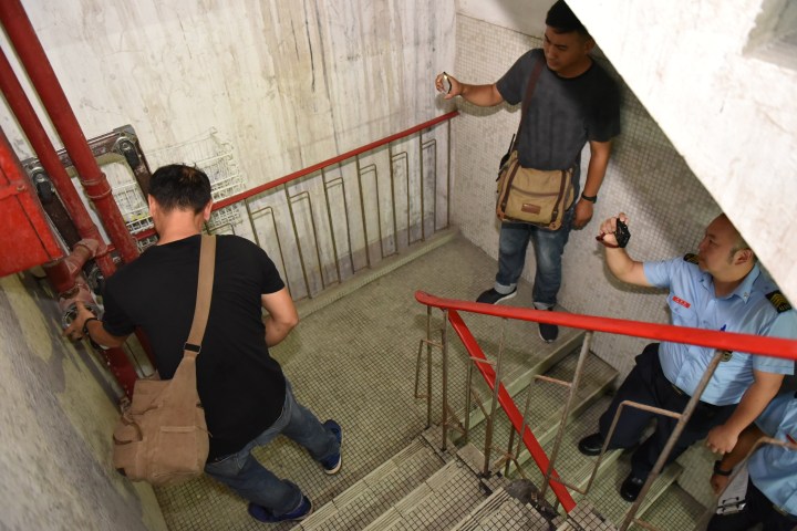 在大廈管理公司人員見証下，消防局人員及消防系統保養公司人員共同測試梯間消防喉